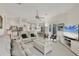 Spacious living room featuring bright natural light and an open floor plan to the kitchen and dining area at 8718 Grey Oaks Ave, Sarasota, FL 34238