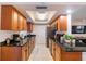 Efficient kitchen with dark countertops, matching wood cabinets, stainless steel appliances, and tile floors at 95 S Briggs Ave, Sarasota, FL 34237