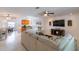 Bright living room with tiled floors, a ceiling fan, and an open floor plan connecting to the kitchen and dining area at 95 S Briggs Ave, Sarasota, FL 34237