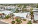 Aerial view of the white house with a canal and palm trees, located in a quiet neighborhood at 10308 Kingfisher W Rd, Bradenton, FL 34209