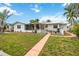 Beautiful back yard with a walkway to the canal, home, and fence at 10308 Kingfisher W Rd, Bradenton, FL 34209