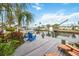 Wooden dock overlooking the canal with chairs and a boat lift at 10308 Kingfisher W Rd, Bradenton, FL 34209