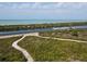Beautiful aerial view of a white boat speeding across calm ocean waters and native tropical plants at 1156 Lemon Bay Dr, Venice, FL 34293
