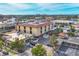 A high aerial view displays the commercial building, a parking lot, and trees with the ocean in the background at 1156 Lemon Bay Dr, Venice, FL 34293