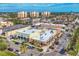 An aerial view of a business district with palm trees and several multi-story buildings in the background at 1156 Lemon Bay Dr, Venice, FL 34293