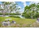 Backyard with stone seating and table beside a calm waterway offering a tranquil setting at 1156 Lemon Bay Dr, Venice, FL 34293