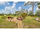 Scenic backyard with a stone-paved patio, bench seating, and meticulously landscaped greenery, ideal for relaxing at 1156 Lemon Bay Dr, Venice, FL 34293