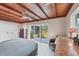 This bedroom has exposed wood beams, white tile flooring, and sliding glass doors looking out to the yard at 1156 Lemon Bay Dr, Venice, FL 34293