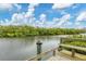 Picturesque view from a wooden dock overlooking a serene waterway, framed by lush greenery at 1156 Lemon Bay Dr, Venice, FL 34293