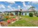 Quaint single-story home with a well-manicured front lawn, garden, and inviting curb appeal at 1156 Lemon Bay Dr, Venice, FL 34293