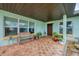 Charming covered front porch with brick flooring and a cozy seating area at 1156 Lemon Bay Dr, Venice, FL 34293