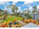 Lush landscaped yard with vibrant bromeliads and stone pathway leading to outdoor space at 1156 Lemon Bay Dr, Venice, FL 34293