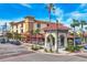 Attractive building with red tile roof, palm trees, and street-side dining, creating an inviting atmosphere at 1156 Lemon Bay Dr, Venice, FL 34293