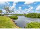 Tranquil waterway view features a dock and lush greenery along the shore, creating a serene environment at 1156 Lemon Bay Dr, Venice, FL 34293