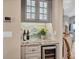 Chic bar area showcases a wine refrigerator, gray cabinetry with a marble countertop, and glassware display at 1280 Dolphin Bay Way # 503, Sarasota, FL 34242