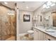 Bathroom with granite countertops, white cabinets, and tiled shower with glass door at 1280 Dolphin Bay Way # 503, Sarasota, FL 34242