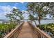 Charming wooden dock extending over tranquil water, surrounded by lush greenery and mature trees at 1280 Dolphin Bay Way # 503, Sarasota, FL 34242