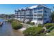 Exterior of a low-rise condominium building with beautiful landscaping near the waterfront at 1280 Dolphin Bay Way # 503, Sarasota, FL 34242
