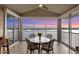 Enclosed lanai with sunset views, tile flooring, and a round table perfect for enjoying waterfront scenery at 1280 Dolphin Bay Way # 503, Sarasota, FL 34242