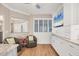 Bright sitting area featuring wood floors, plantation shutters, comfortable chairs, and custom built-in cabinetry at 1280 Dolphin Bay Way # 503, Sarasota, FL 34242
