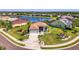 Aerial view of a lakeside community featuring a single-story home with mature landscaping and lush green lawns at 12830 24Th Street E Cir, Parrish, FL 34219