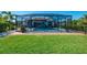 Beautiful backyard features a screened-in pool area, patio, and a well-manicured lawn at 12830 24Th Street E Cir, Parrish, FL 34219