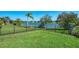 Backyard overlooking a serene lake with black aluminum fence surrounding the manicured lawn at 12830 24Th Street E Cir, Parrish, FL 34219