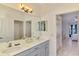 Bathroom vanity featuring dual sinks, gray cabinets and a view to the main bedroom at 12830 24Th Street E Cir, Parrish, FL 34219