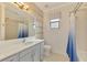Bathroom features a single vanity, a window, and a shower with a blue shower curtain at 12830 24Th Street E Cir, Parrish, FL 34219