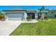 Inviting home with manicured lawn, two-car garage, and covered entry, framed by lush landscaping at 12830 24Th Street E Cir, Parrish, FL 34219