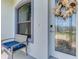 Close-up of a charming front door with decorative glass, a fall wreath, and an adjacent window at 12830 24Th Street E Cir, Parrish, FL 34219