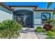 Covered entry with stone walkway, lush greenery, and a decorative wreath on the front door at 12830 24Th Street E Cir, Parrish, FL 34219