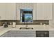 Kitchen sink with stainless steel appliances and decorative window valance overlooking a lake view at 12830 24Th Street E Cir, Parrish, FL 34219