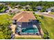 Aerial view of screened in pool, tile patio, meticulously landscaped yard, and lush tropical foliage at 12830 24Th Street E Cir, Parrish, FL 34219
