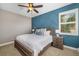 Bedroom featuring a wood-framed bed, stylish wall accents, and natural light from a window at 141 Bella Vista Ter # 34D, Nokomis, FL 34275