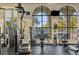 Well-equipped gym with state-of-the-art exercise equipment and scenic views of pool area through large windows at 141 Bella Vista Ter # 34D, Nokomis, FL 34275