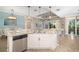 Kitchen island with granite countertop and stainless steel dishwasher with views of the living area at 141 Bella Vista Ter # 34D, Nokomis, FL 34275