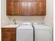 Laundry room featuring cabinets, utility sink, washer, and dryer at 141 Bella Vista Ter # 34D, Nokomis, FL 34275