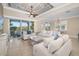 Bright living room with comfortable white sofas, tile flooring, and scenic views from sliding glass doors at 141 Bella Vista Ter # 34D, Nokomis, FL 34275