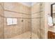 Tiled shower stall featuring glass door, tile accents, and built-in shelf at 141 Bella Vista Ter # 34D, Nokomis, FL 34275