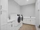 Bright laundry room featuring a washer, dryer, counter space, and cabinet storage at 1613 4Th E St, Palmetto, FL 34221