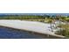 A pristine private beach with calm waters, framed by lush greenery and swaying palms at 1613 4Th E St, Palmetto, FL 34221