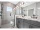 Modern bathroom with double vanity, stone countertops, a large mirror and a glass-enclosed shower with gray tiling at 1617 Sea Haven Dr # 502, Punta Gorda, FL 33950