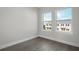 Bright bedroom with light hard wood floors, trim and two windows showing exterior homes and mature landscaping at 1617 Sea Haven Dr # 502, Punta Gorda, FL 33950