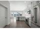 Clean kitchen with stainless steel appliances, white cabinets, marble countertops and hardwood floors leading to a living area at 1617 Sea Haven Dr # 502, Punta Gorda, FL 33950