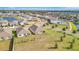 An aerial view of a neighborhood with well-maintained lawns and a pond at 16341 Little Garden Dr, Wimauma, FL 33598
