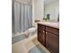 Bathroom featuring a shower with gray curtains, tile flooring, and a brown vanity at 16341 Little Garden Dr, Wimauma, FL 33598