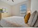 Bedroom featuring a queen-sized bed, bedside table, and a window with horizontal blinds at 16341 Little Garden Dr, Wimauma, FL 33598