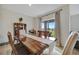 Dining room with a long wooden table, chairs, and sliding door to outside at 16341 Little Garden Dr, Wimauma, FL 33598