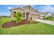 Charming house with a verdant lawn, complemented by landscaping, and featuring a two-car garage at 16341 Little Garden Dr, Wimauma, FL 33598